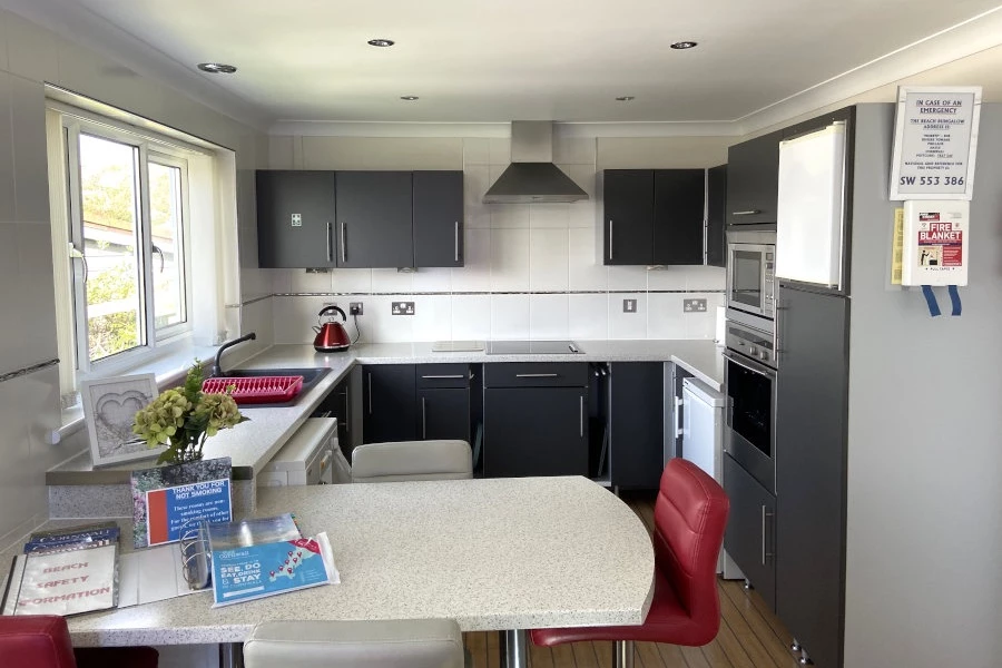 A modern and bright kitchen with a washing machine and breakfast bar