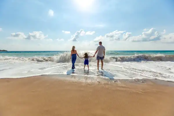 Family walking on Hayle beach into the sea