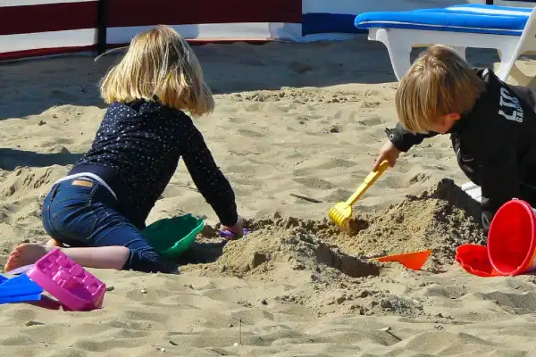 Girl and Boy playing on Hayle Beach in the golden sand